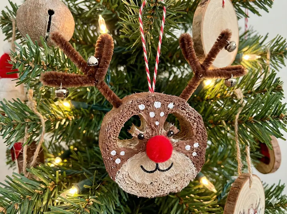 Whimsical reindeer ornament made from loofah with painted features, pipe cleaner antlers, red nose